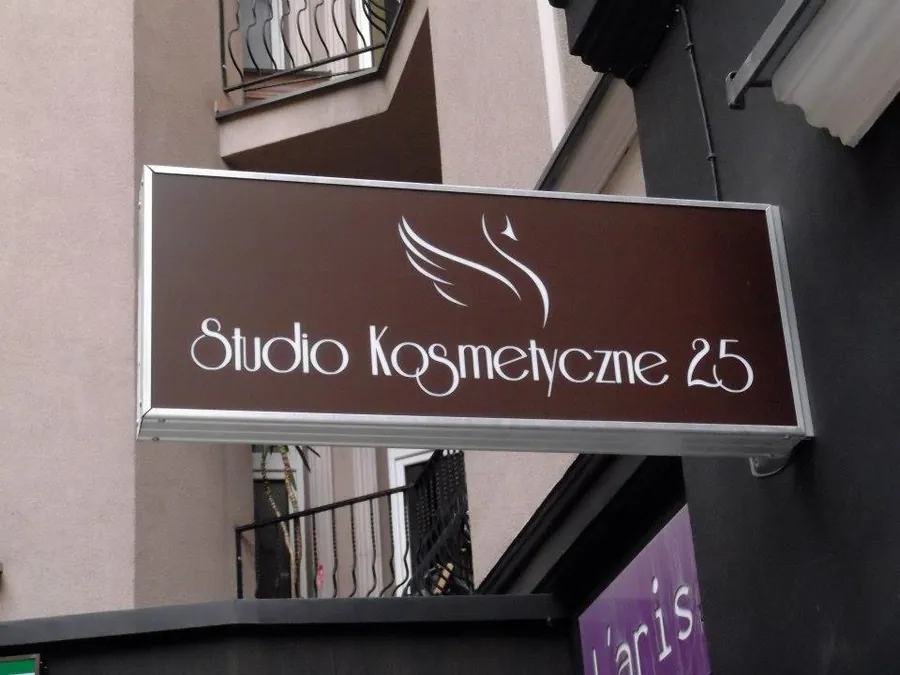 Podświetlany kaseton salonu kosmetycznego na elewacji kamienicy