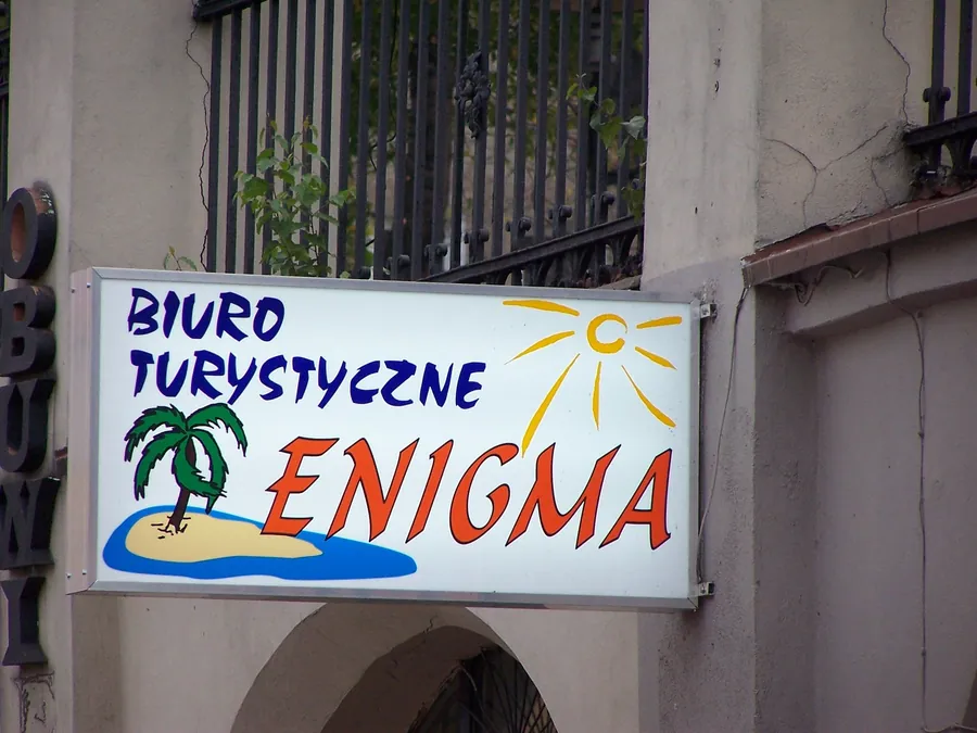 Kaseton biura turystycznego z grafiką, zamontowany na elewacji