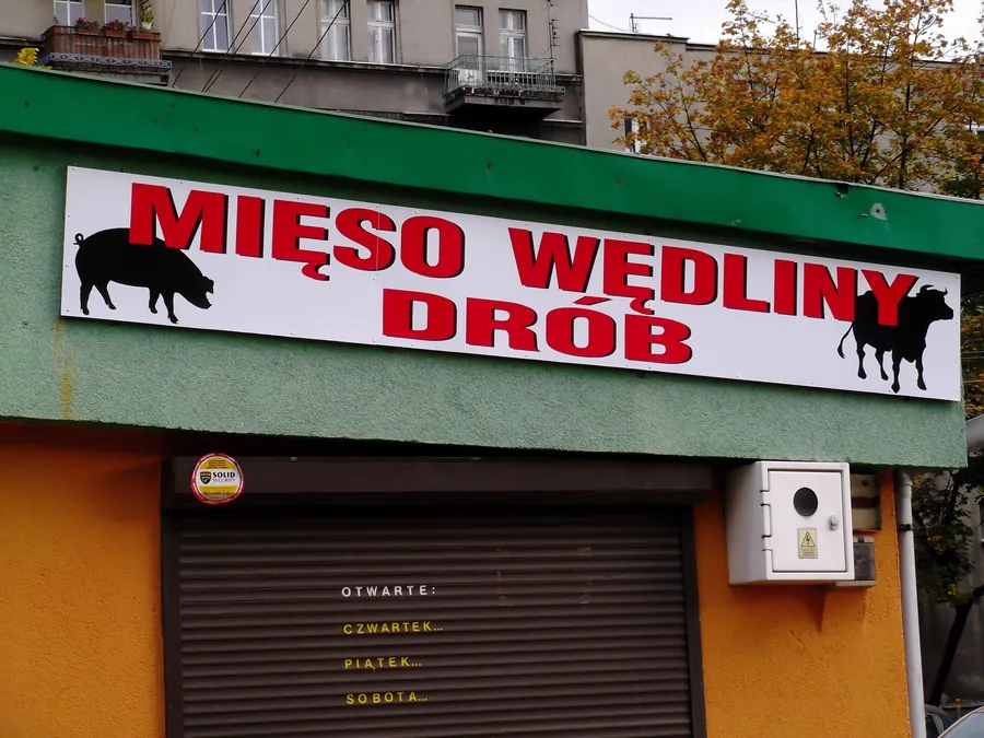 Szyld sklepu mięsnego z grafiką nad witryną