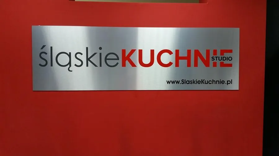Szyld z logotypem na czerwonym tle we wnętrzu lokalu